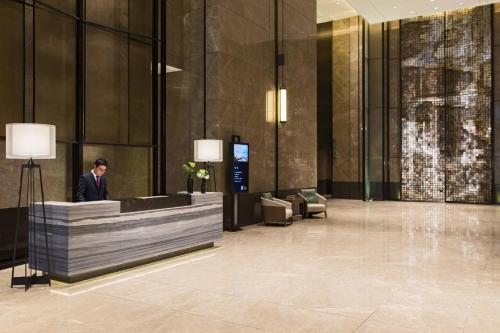 a man standing in the lobby of a building at Chongqing Marriott Hotel in Chongqing