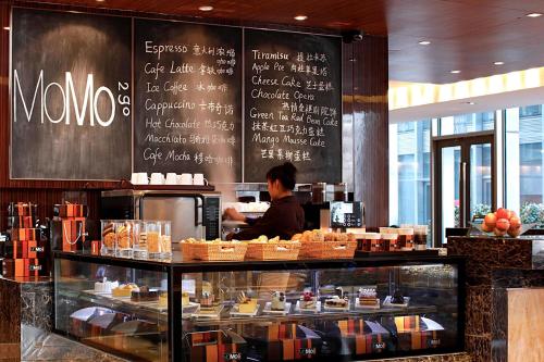 a man standing behind a counter in a restaurant at Courtyard by Marriott Shanghai Jiading in Jiading
