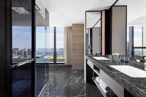 a bathroom with two sinks and a large window at Marriott Nanjing South Hotel in Jiangning