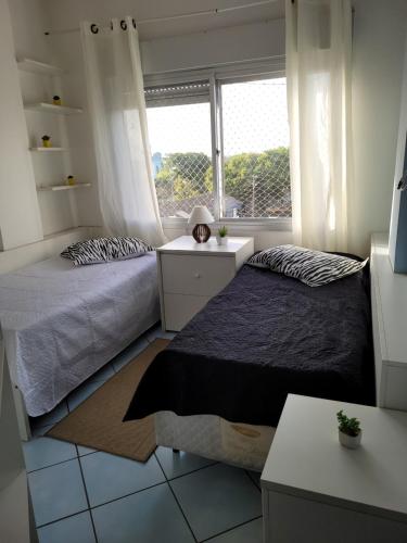 a bedroom with two beds and a window at Vista para o Guaíba in Porto Alegre