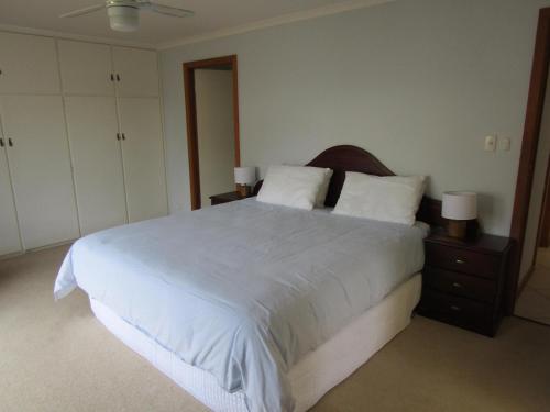 ein Schlafzimmer mit einem großen Bett mit weißer Bettwäsche und Kissen in der Unterkunft Narnia in Brentwood