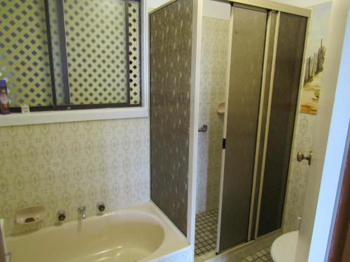 ein Badezimmer mit einer Dusche, einer Badewanne und einem Waschbecken in der Unterkunft Narnia in Brentwood