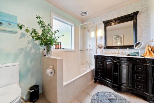 a bathroom with a tub and a sink and a mirror at Ourania Luxury Villa with unforgettable sea views in Rye