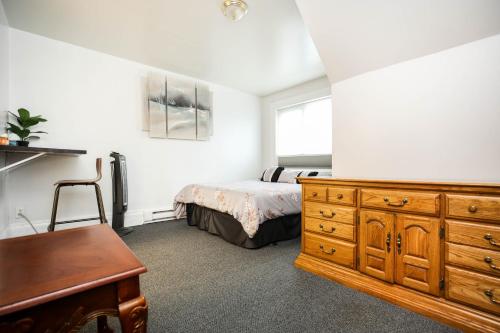 a bedroom with a bed and a dresser and a desk at Wolseley the heart of the city ! in Winnipeg