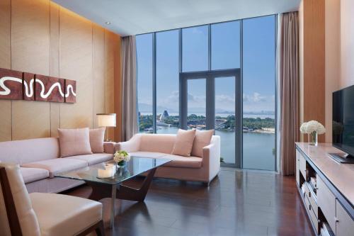 a living room with a couch and a tv and glass doors at The OCT Harbour, Shenzhen - Marriott Executive Apartments in Shenzhen