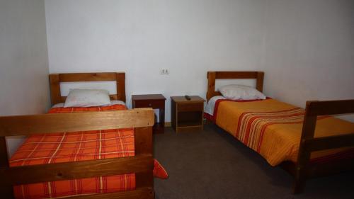 Habitación con 2 camas y 2 mesitas de noche en Residencial familiar El Valle en Calama