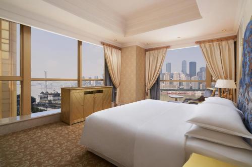 重慶市にあるSheraton Chongqing Hotelのベッドと大きな窓が備わるホテルルームです。