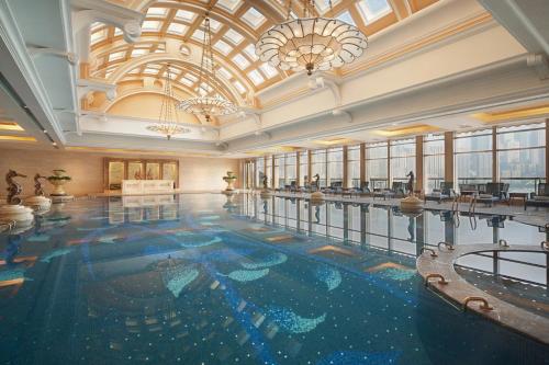 a swimming pool in a building with a large ceiling at Sheraton Chongqing Hotel in Chongqing