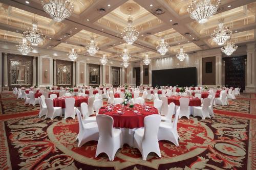 a large banquet hall with tables and chairs and a screen at Sheraton Chongqing Hotel in Chongqing