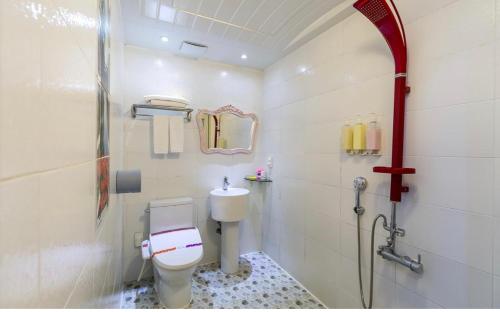 a bathroom with a toilet and a shower at Hera drive in hotel in Jeju