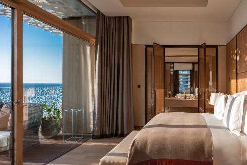 a bedroom with a large bed and a large window at Bulgari Resort, Dubai in Dubai