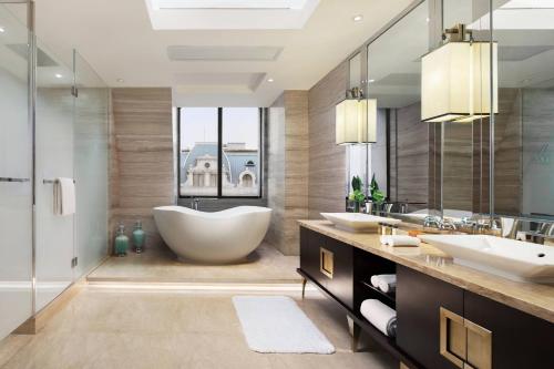 un bagno con due lavandini e una grande vasca di Courtyard by Marriott Shanghai Changfeng Park a Shanghai