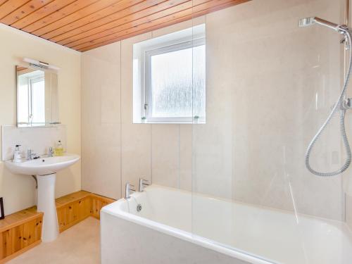 een badkamer met een wit bad en een wastafel bij Bunloit Farmhouse - Uk45397 in Lewiston
