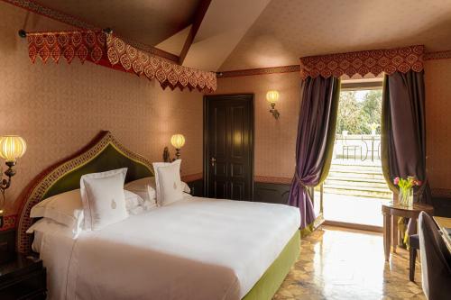 a bedroom with a large white bed and a window at Villa Cora in Florence