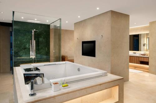 een grote badkamer met een bad en een wastafel bij Le Meridien Shenyang Heping in Shenyang