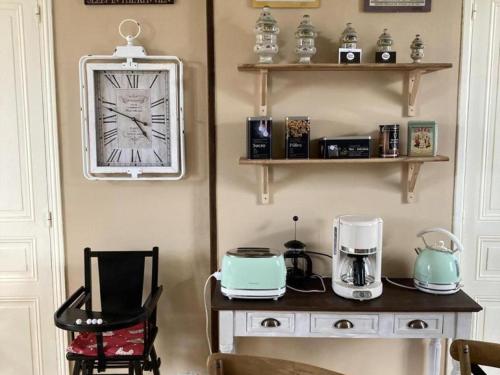 une chambre avec une table et une horloge sur le mur dans l'établissement Charmant Gîte à Sepmes: Jardin Privé, Accès Wifi, Proche Châteaux de la Loire et Vignobles - FR-1-381-552, à Sepmes