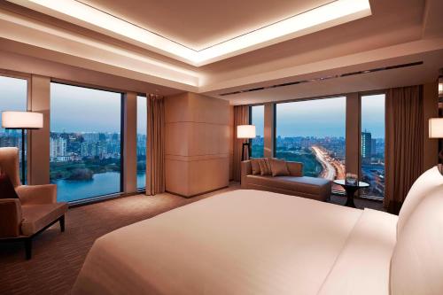 a hotel room with a large bed and large windows at Shanghai Marriott Hotel Parkview in Shanghai