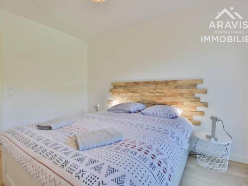 a bedroom with a bed with a wooden headboard at Appartement Samoëns, 2 pièces, 4 personnes - FR-1-391-178 in Samoëns