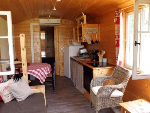 - une cuisine dans une cabane en rondins avec une table dans l'établissement Roulotte cosy avec tout confort au cœur du Val de Loire, idéale pour découvrir les châteaux et la Sologne - FR-1-590-384, à Lion-en-Sullias