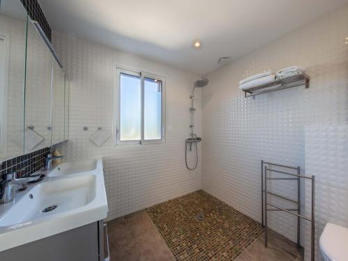 uma casa de banho com um lavatório, um chuveiro e uma janela. em Gîte Jouy-le-Potier, 3 pièces, 4 personnes - FR-1-590-396 em Jouy-le-Potier