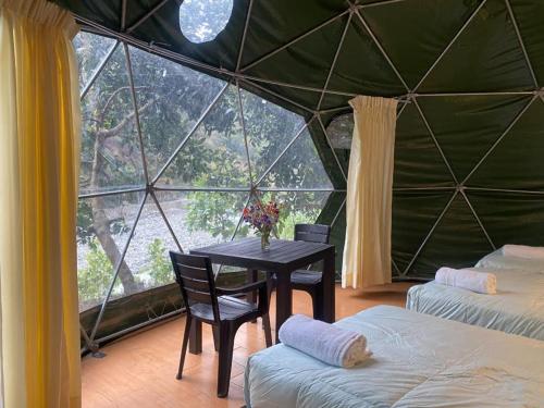 una habitación con mesa y sillas en una tienda de campaña en Sky Lodge Domes Loreta Playa Sahuayaco en Sahuayacu