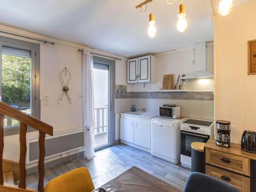 une cuisine avec des appareils électroménagers blancs et une fenêtre dans l'établissement Maison individuelle avec jardinet et salle de jeux - Cauterets - FR-1-401-271, à Cauterets
