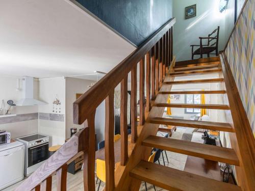 Un escalier en bois mène à une cuisine et à un salon. dans l'établissement Maison Cauterets, 5 pièces, 10 personnes - FR-1-401-271, à Cauterets