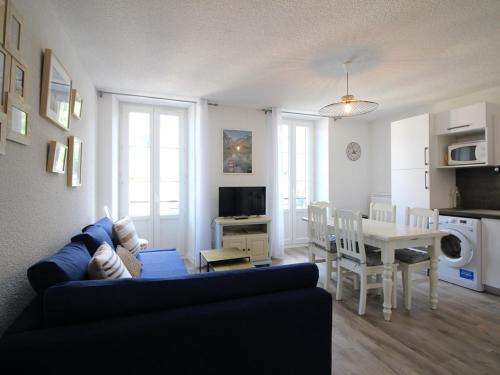 un salon avec un canapé bleu et une table dans l'établissement T3 lumineux avec WiFi à 300m des thermes de Mont-Dore, classé 2 étoiles, équipé pour 5 personnes - FR-1-608-255, à Le Mont-Dore