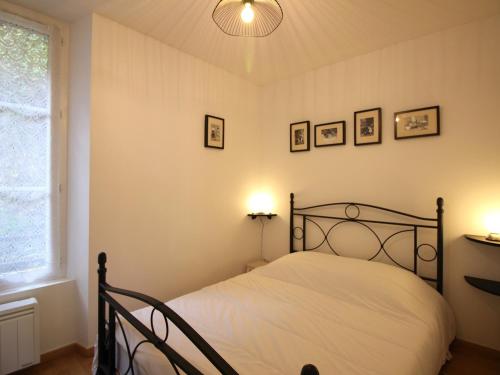 une chambre avec un lit et deux tableaux au mur dans l'établissement T3 lumineux avec WiFi à 300m des thermes de Mont-Dore, classé 2 étoiles, équipé pour 5 personnes - FR-1-608-255, à Le Mont-Dore