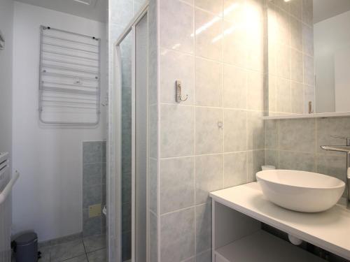 une salle de bain blanche avec un lavabo et une douche dans l'établissement T3 lumineux avec WiFi à 300m des thermes de Mont-Dore, classé 2 étoiles, équipé pour 5 personnes - FR-1-608-255, à Le Mont-Dore