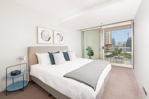 a bedroom with a large bed and a large window at DH707 - 1 bedroom unit Victoria St - Darlinghurst in Sydney