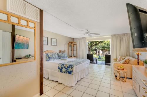 a bedroom with a bed and a living room at Eldorado D106 in Kahana
