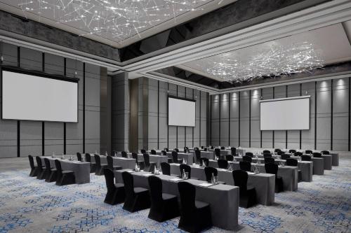 an empty conference room with chairs and blank screens at Shanghai Marriott Hotel Pudong South in Nanhui