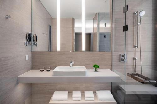 a bathroom with a sink and a mirror at Courtyard by Marriott Shanghai Minhang in Shanghai