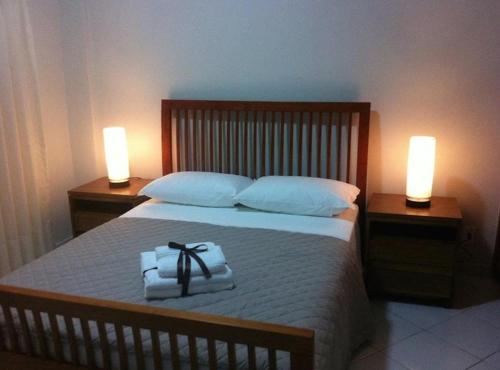 1 dormitorio con 1 cama con 2 toallas y 2 luces en Dream Away Pipa Residence en Pipa