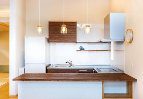 a kitchen with white cabinets and a sink at Chalet Setsugekka in Hakuba