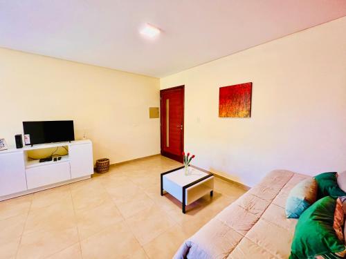een woonkamer met een bank en een tv bij Quinta Colores •con cochera• in Mendoza