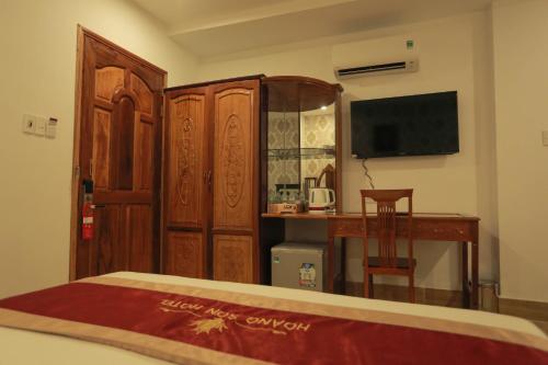a bedroom with a bed and a desk and a television at Hoang Son Hotel - Can Tho in Can Tho