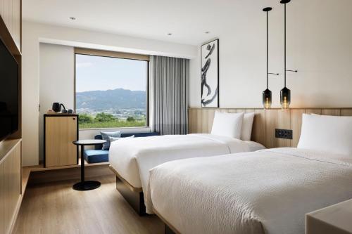 うきは市にあるフェアフィールド･バイ･マリオット･福岡うきはのベッド2台と窓が備わるホテルルームです。