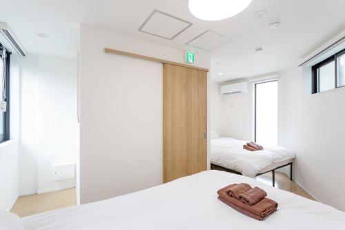 a bedroom with two beds with towels on them at Shinjuku City House 新宿シティハウス in Tokyo
