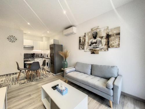 un salon avec un canapé et une table dans l'établissement Escapades Ensoleillées, à Nice