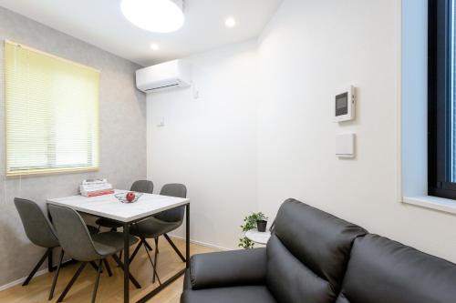 a living room with a table and a couch at Shinjuku City House 新宿シティハウス in Tokyo