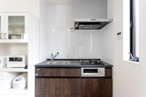 a kitchen with a sink and a stove top oven at Shinjuku City House 新宿シティハウス in Tokyo