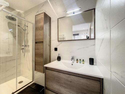 une salle de bain avec un lavabo, une douche et un miroir dans l'établissement Escapades Ensoleillées, à Nice