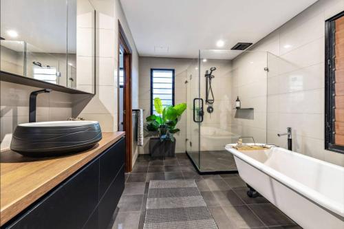baño con bañera grande y lavamanos en Lush Tropical Paradise Home - Darwin City, en Stuart Park