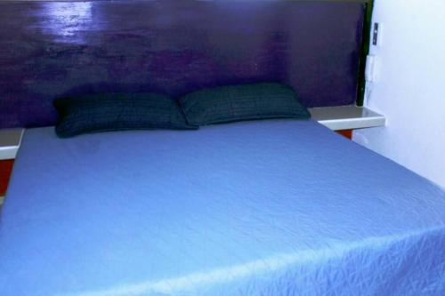 uma cama azul com duas almofadas em cima em departamento Sofía em Jaluco