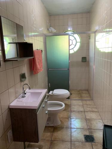 a bathroom with a toilet and a sink and a shower at Hostel 858 in Pelotas