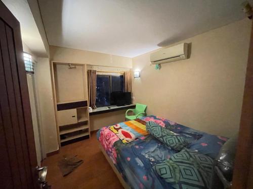 een kleine slaapkamer met een bed en een raam bij Highlander Apartemen Rajawali in Jakarta