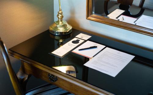 a desk with a lamp and a pen and papers on it at Stamford Plaza Brisbane in Brisbane