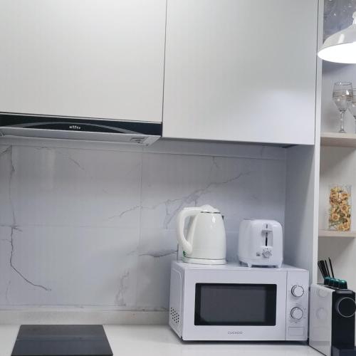 a kitchen with a microwave and a coffee maker on top of it at Yangyang Ocean Stay 환상적 전면 오션뷰 in Yangyang